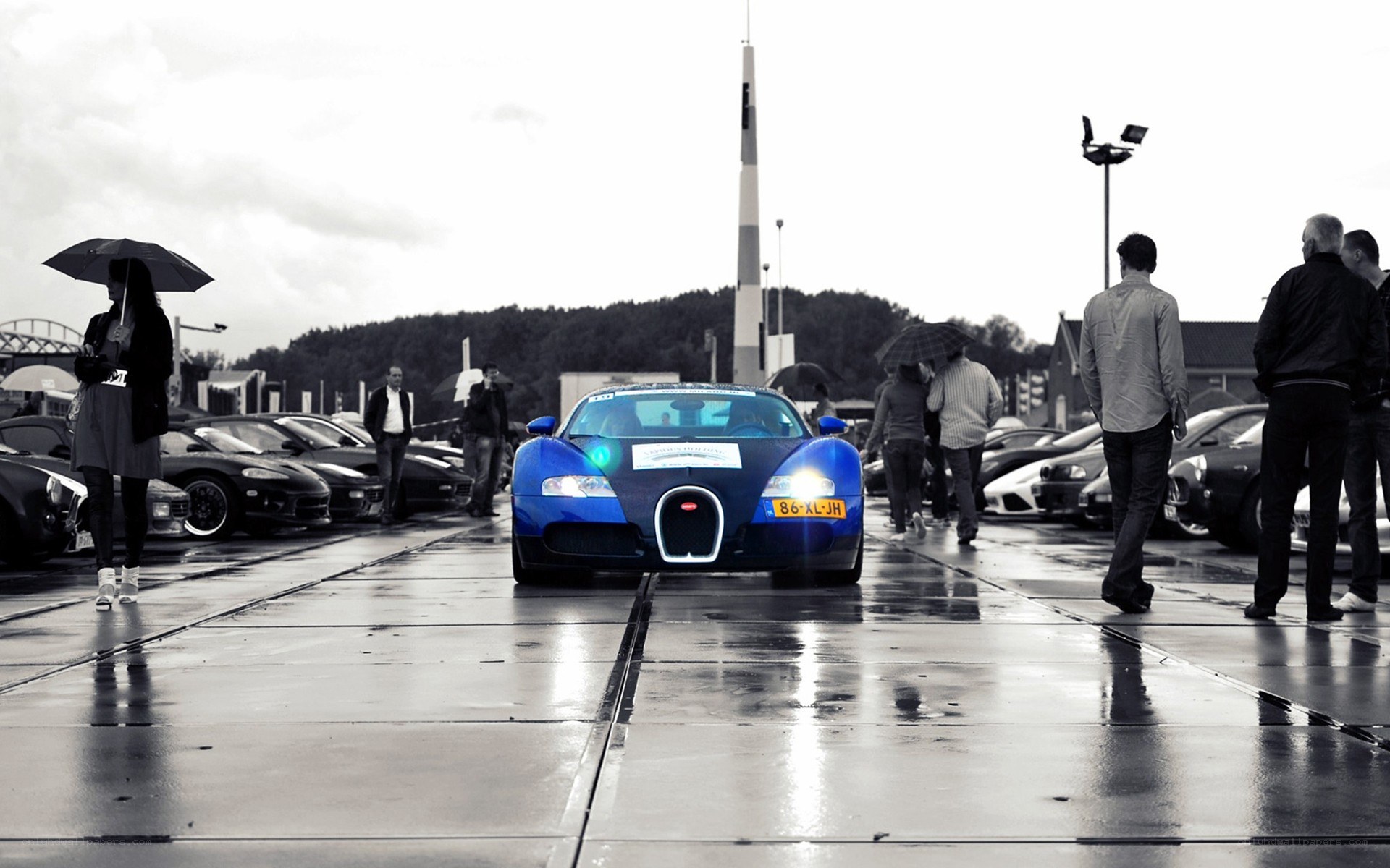Blue Bugatti on wet pavement