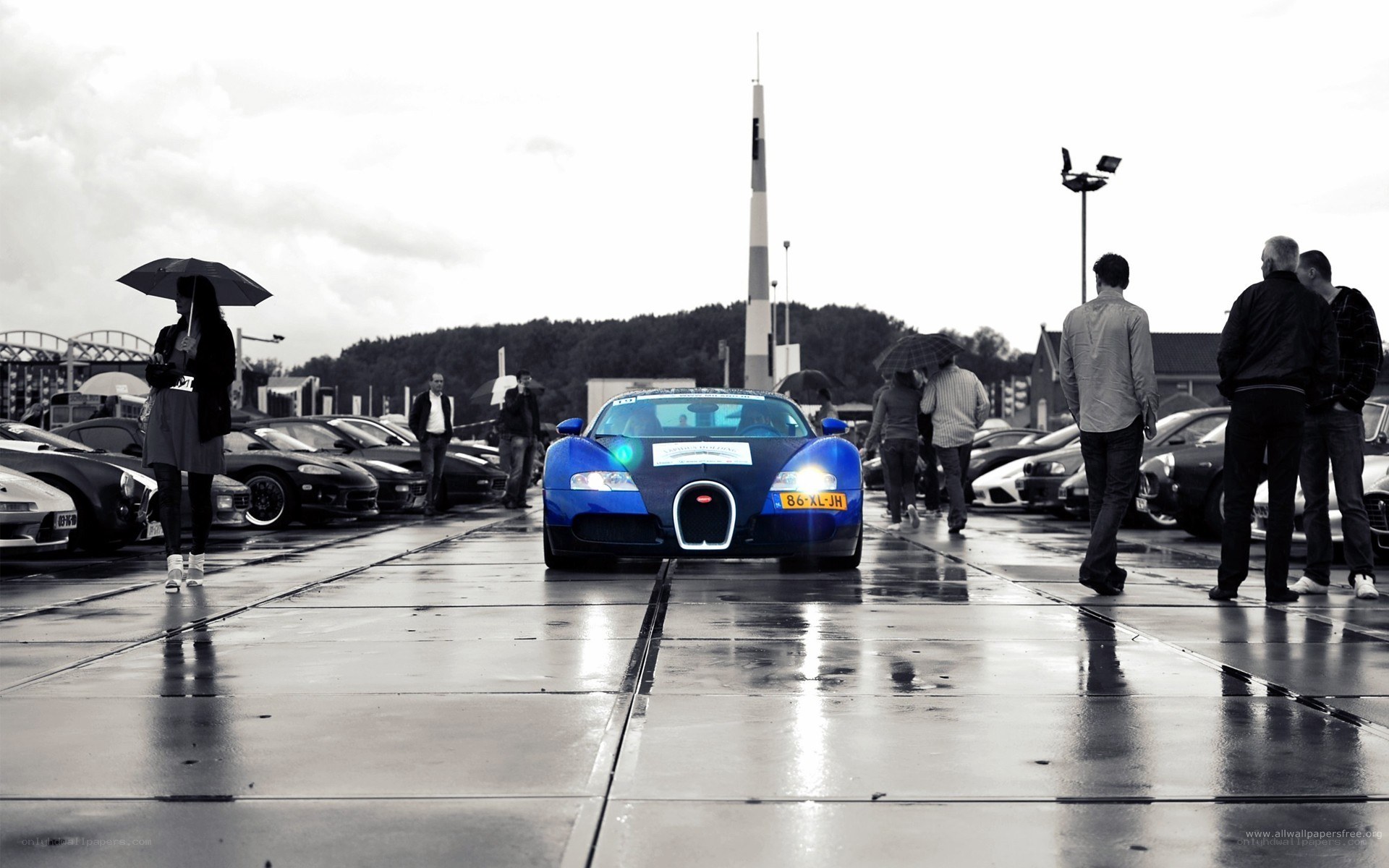 Blue Bugatti on wet pavement