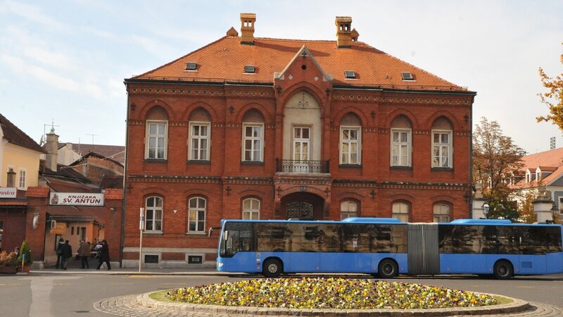 Blue bus in front of red brick building