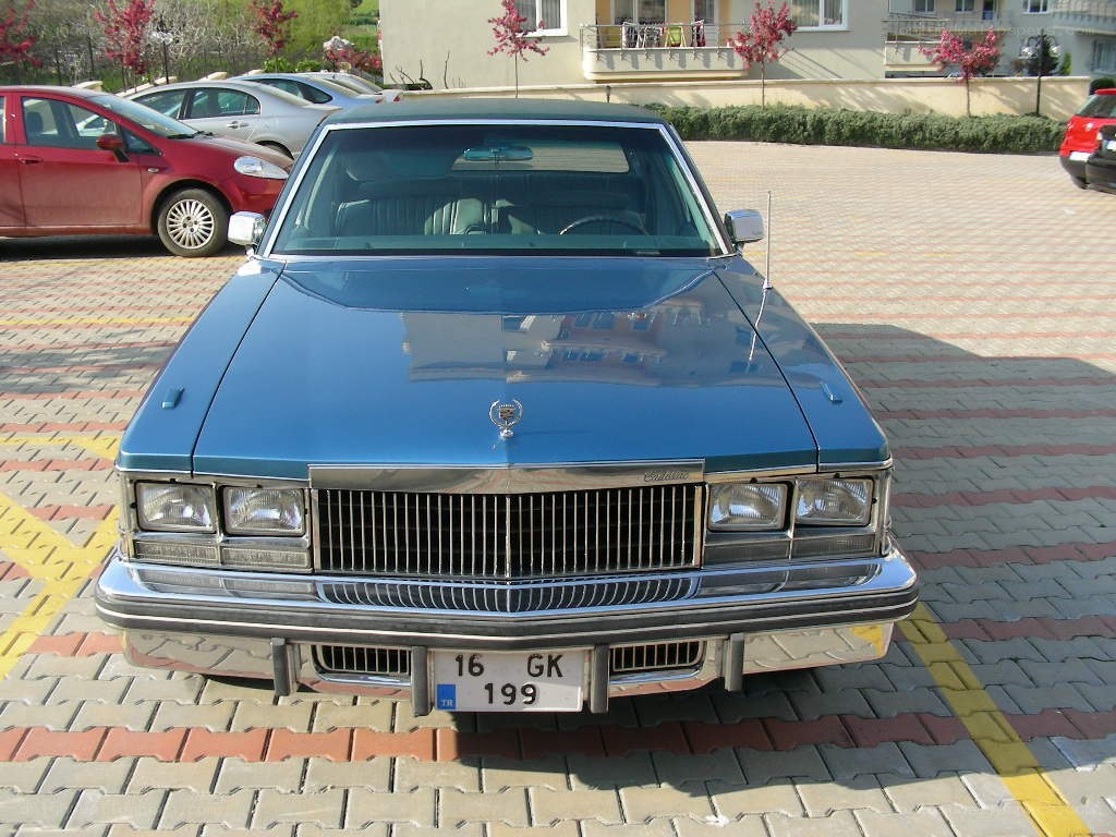 blue cadillac parked in lot