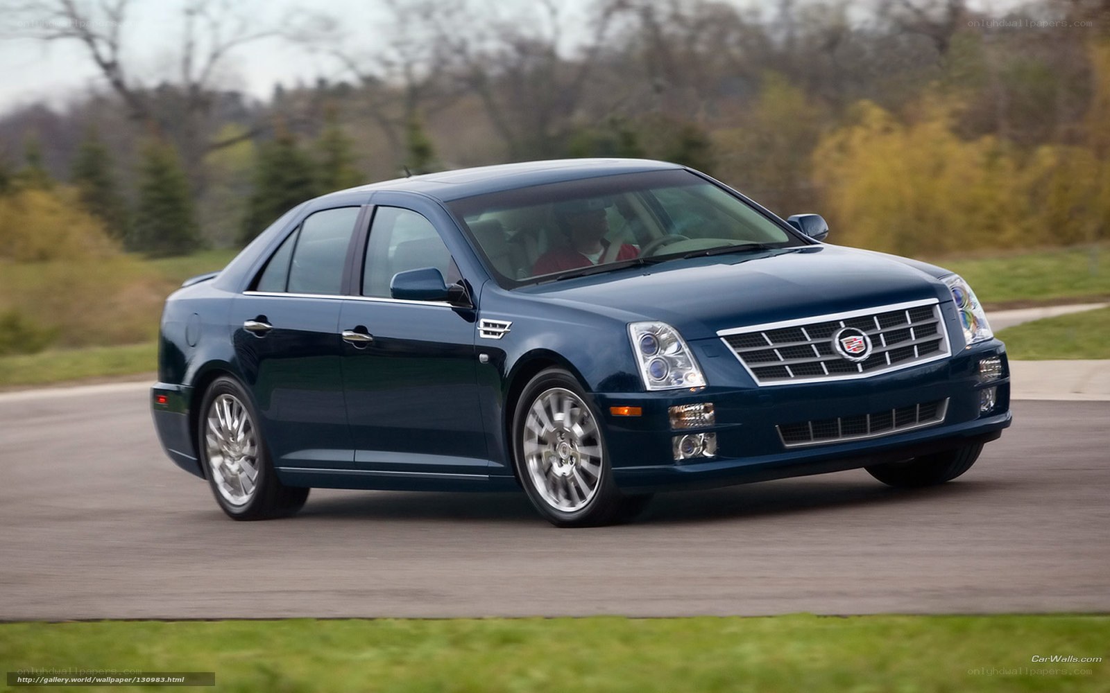 blue cadillac sedan in motion
