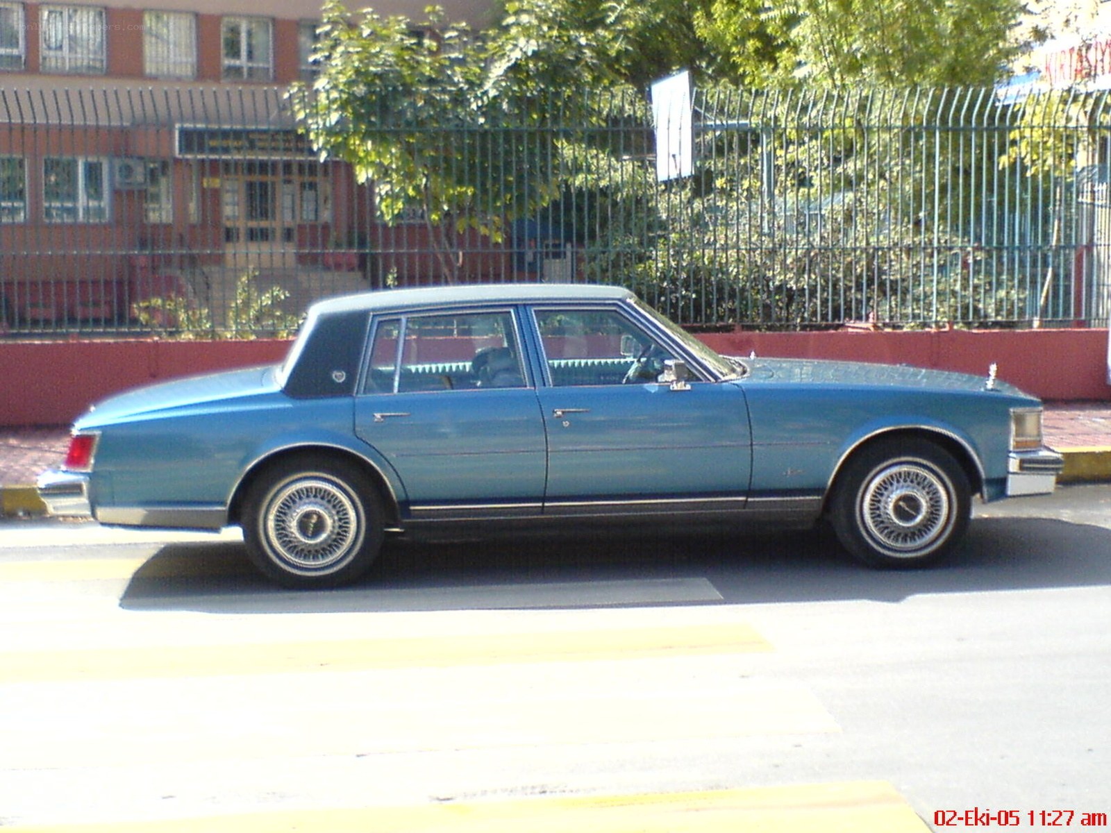 blue cadillac sedan on street
