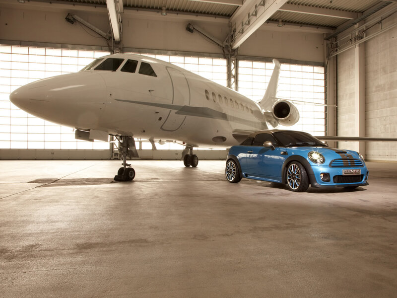 Blue car and private jet in hangar