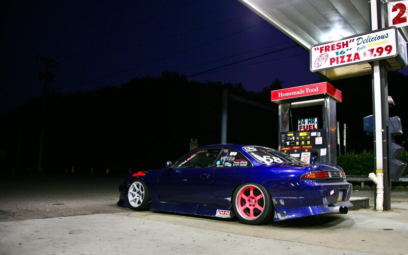 Blue car at gas station at night