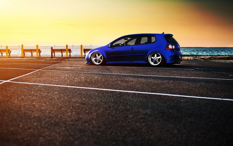 blue car at sunset by the sea