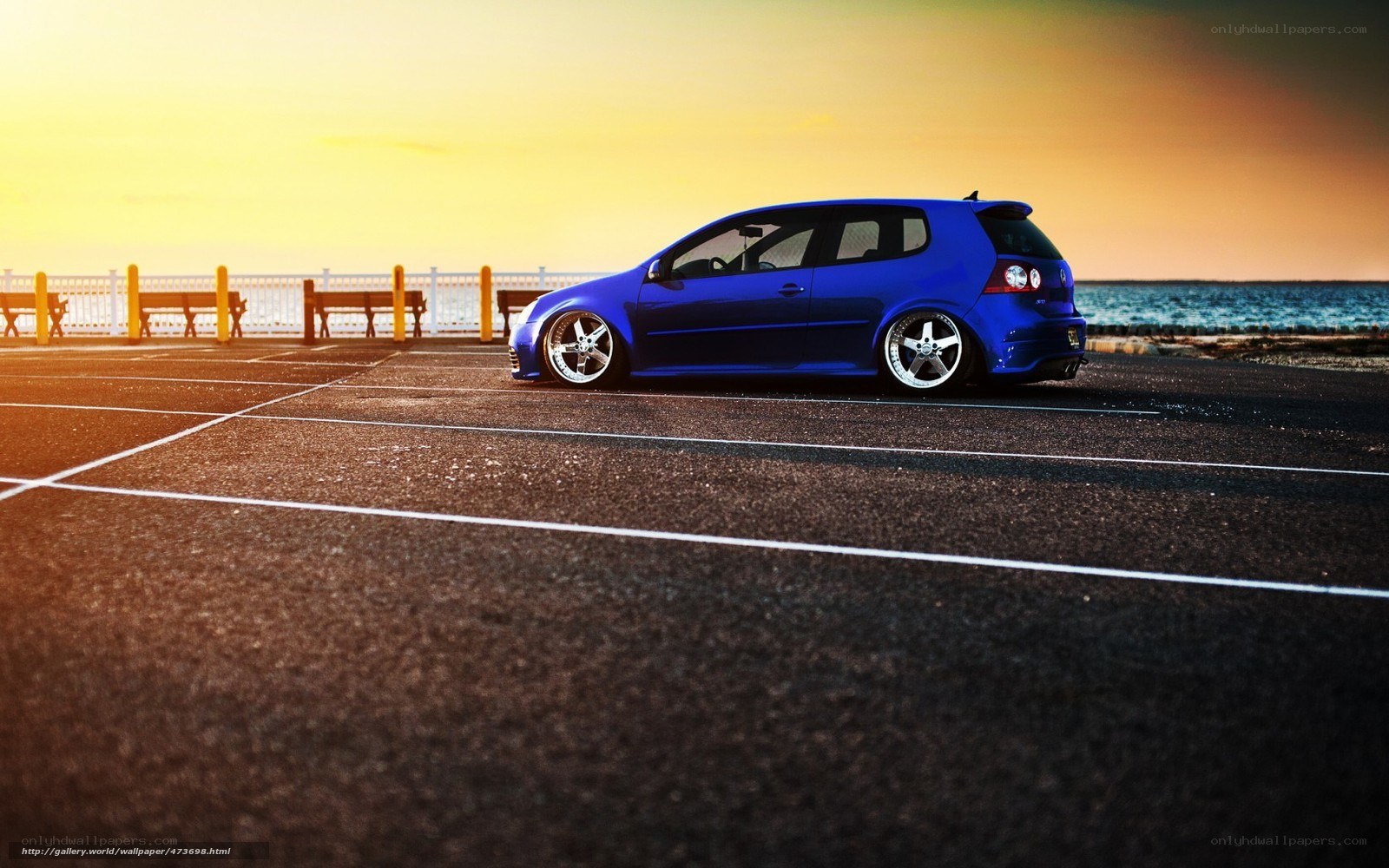 Blue car at sunset by the sea