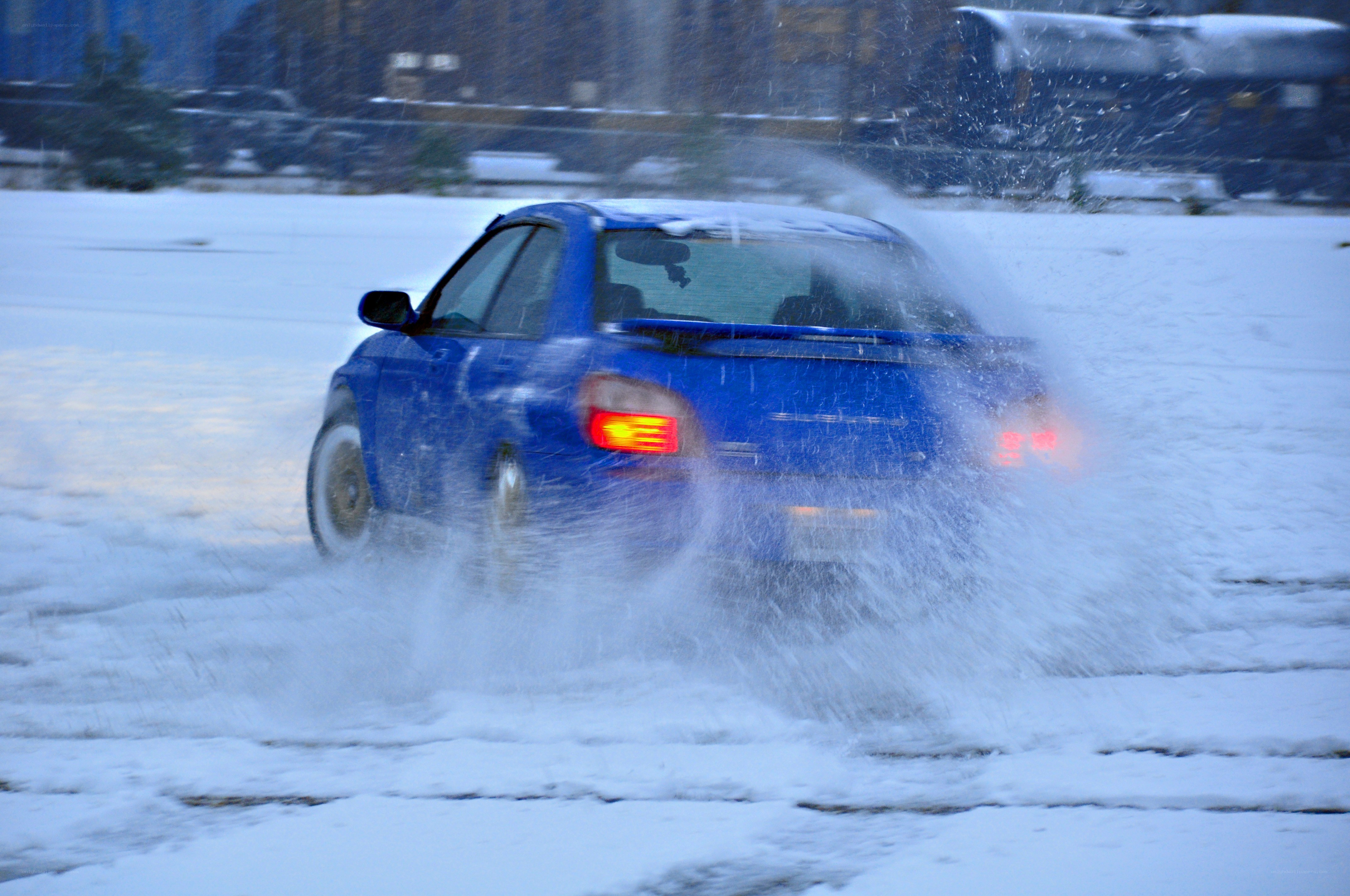 Blue car driving in snow