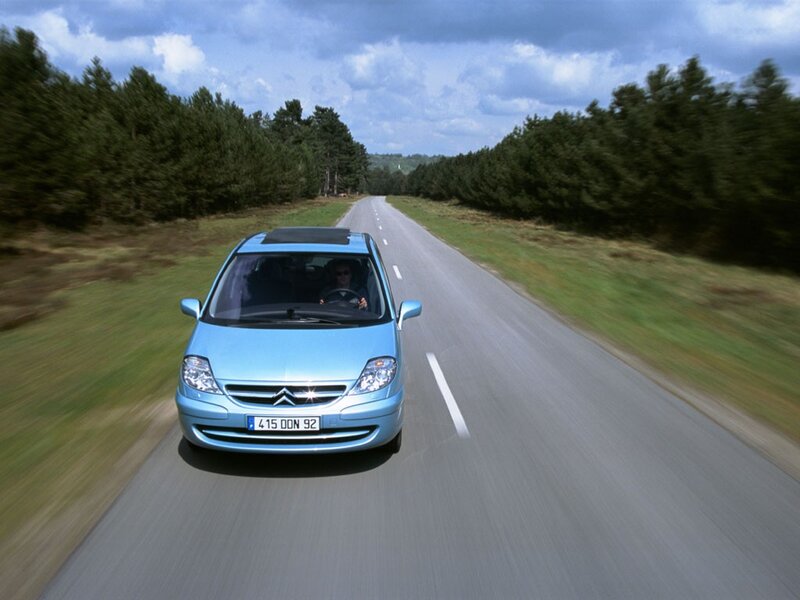 Blue car driving on country road