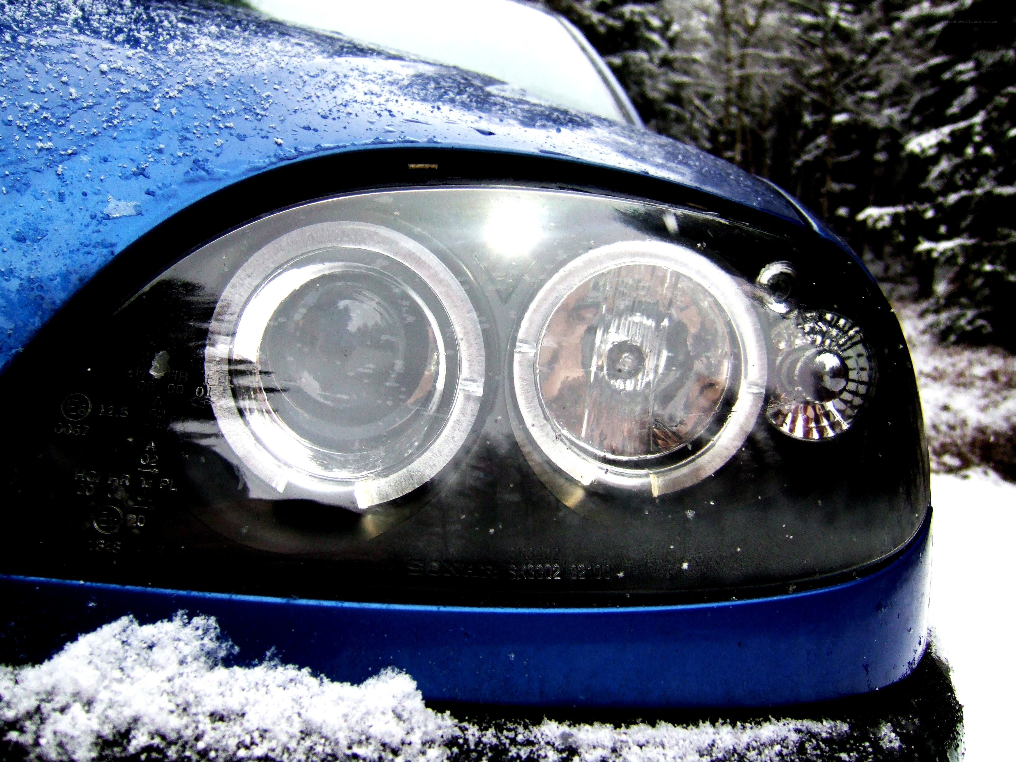 Blue car headlight in snow