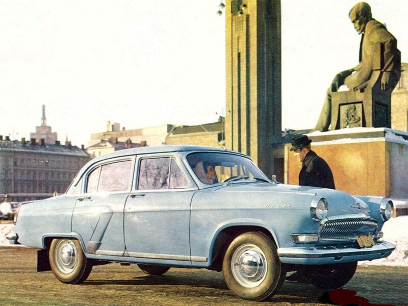 Blue car in front of statue
