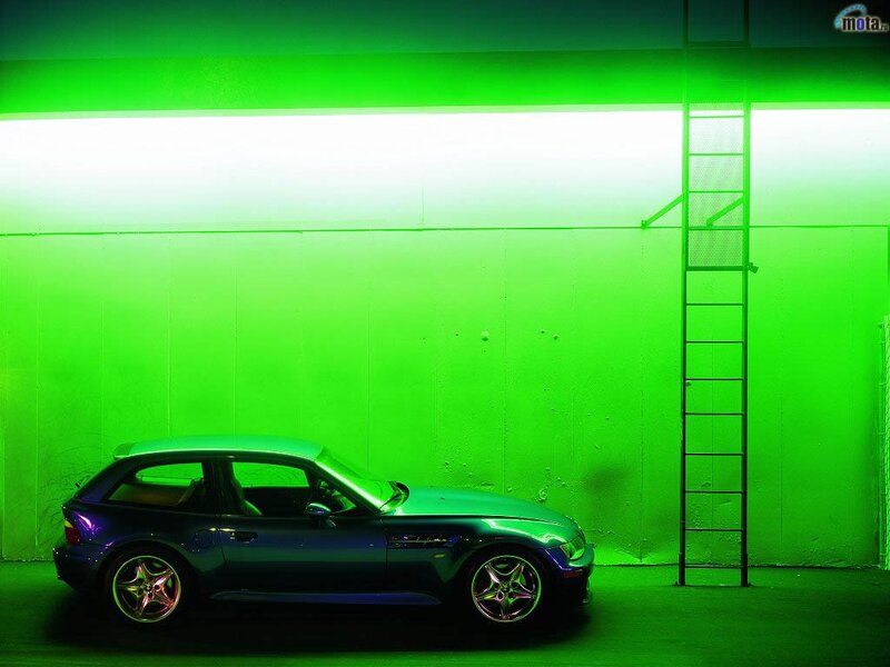 Blue car in green-lit garage