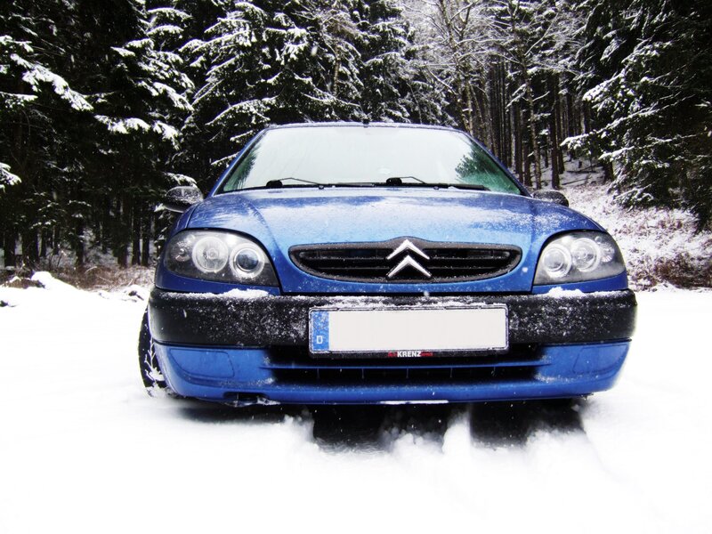 Blue car in snowy forest