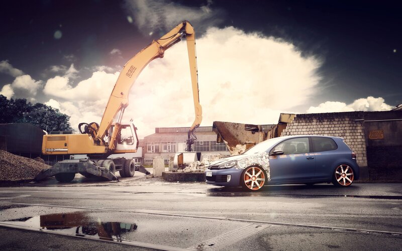 Blue car near excavator at construction site