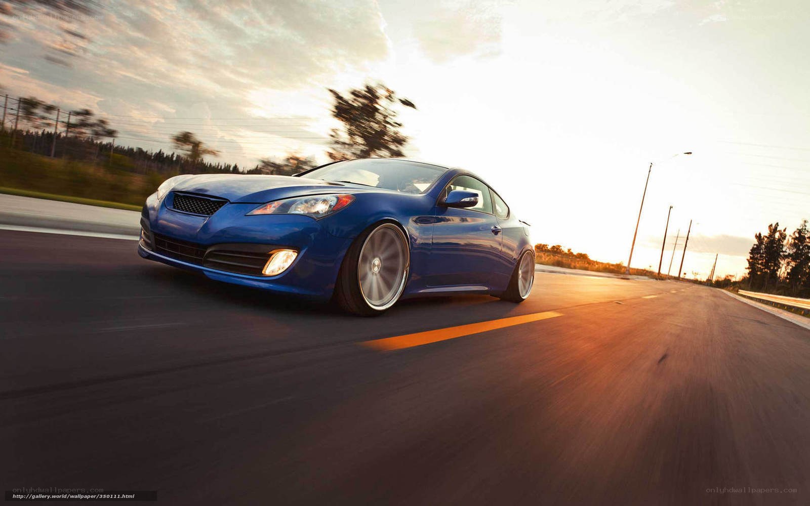 Blue car on a road at sunset
