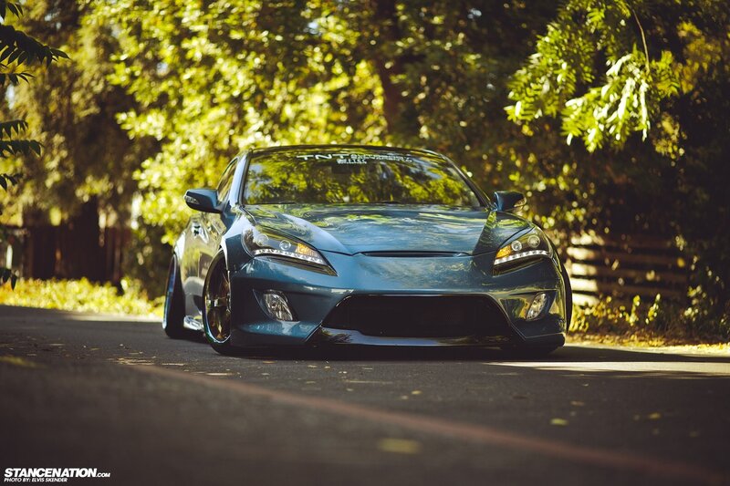 Blue car on a tree-lined road