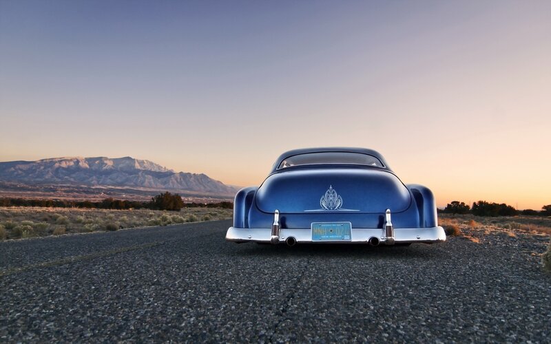 Blue car on desert road