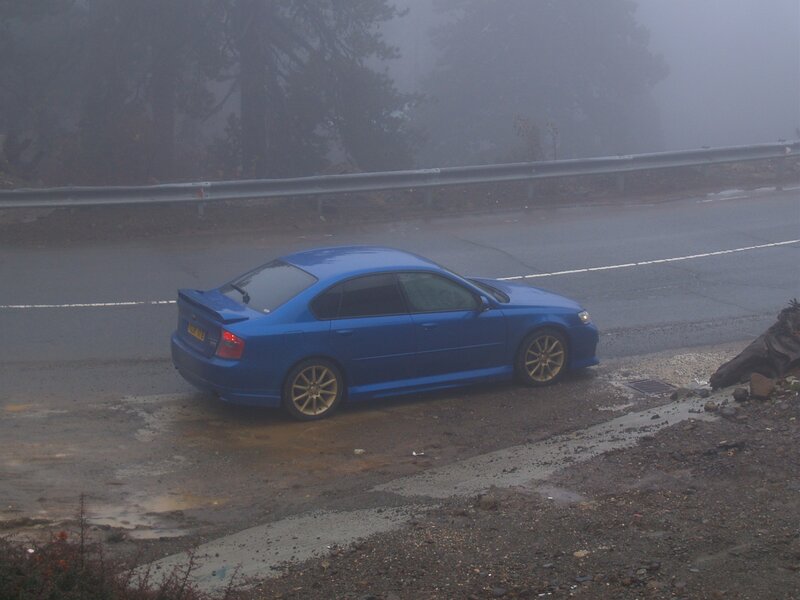 Blue car on foggy road