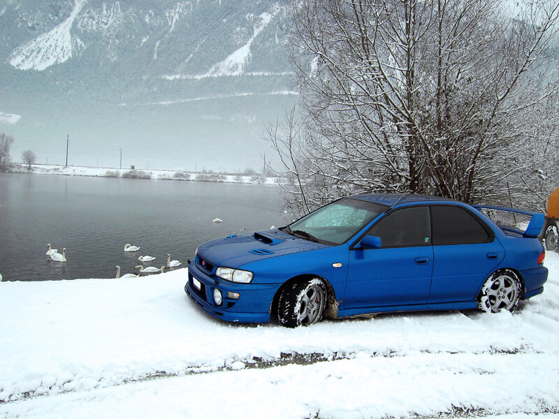 Blue car on snowy lake shore