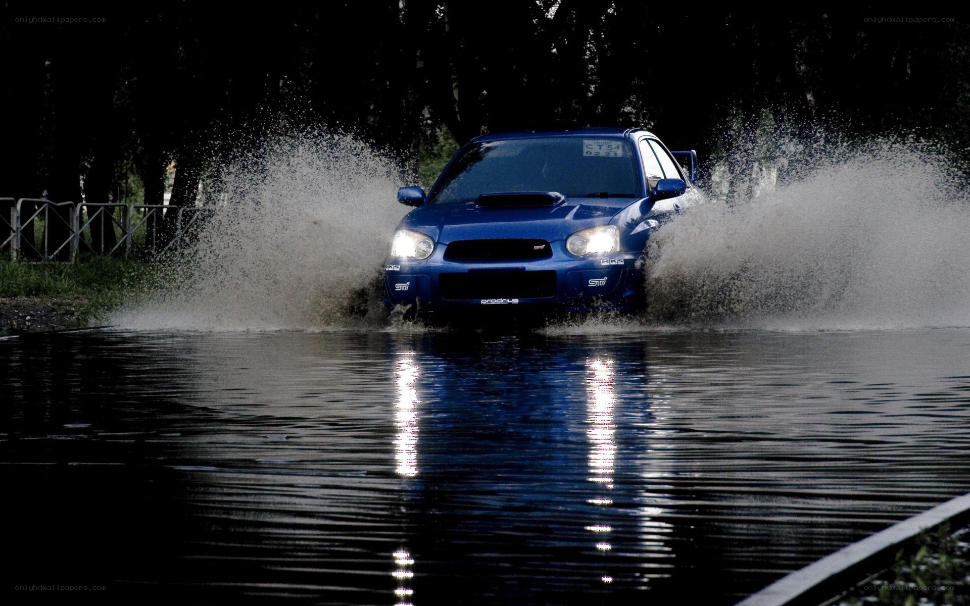 blue car splashing through water