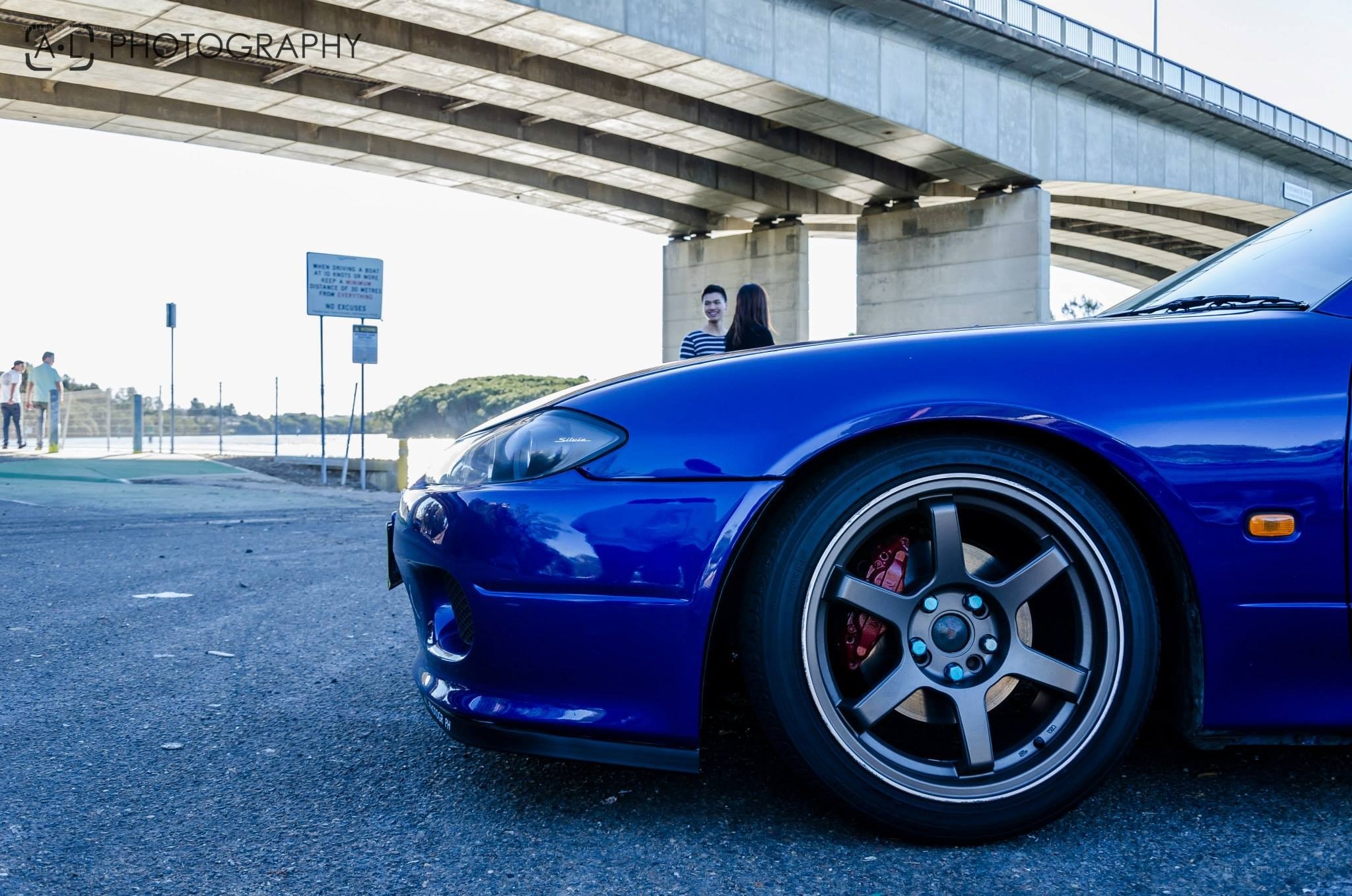 Blue car under a bridge