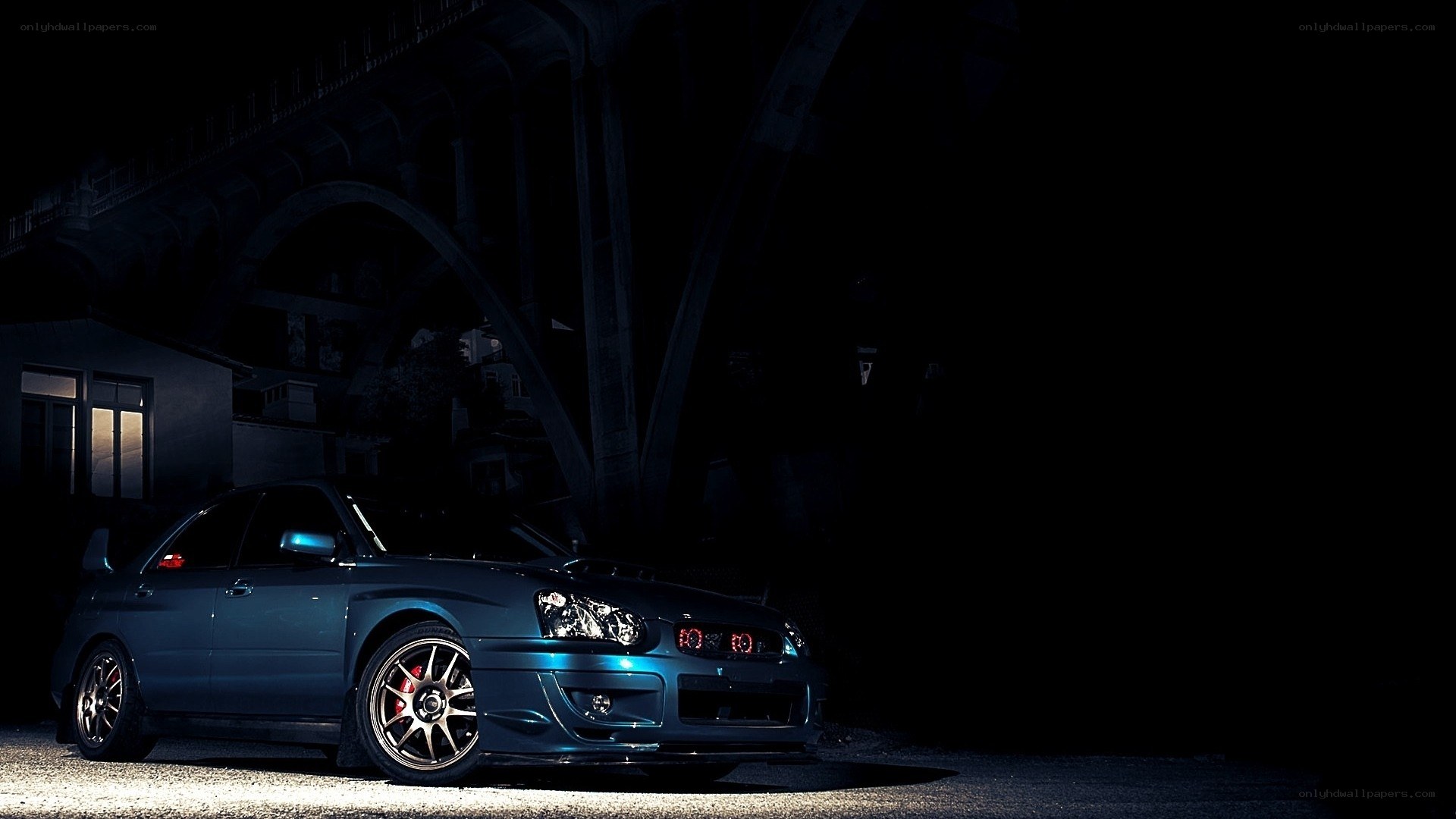 blue car under a bridge at night