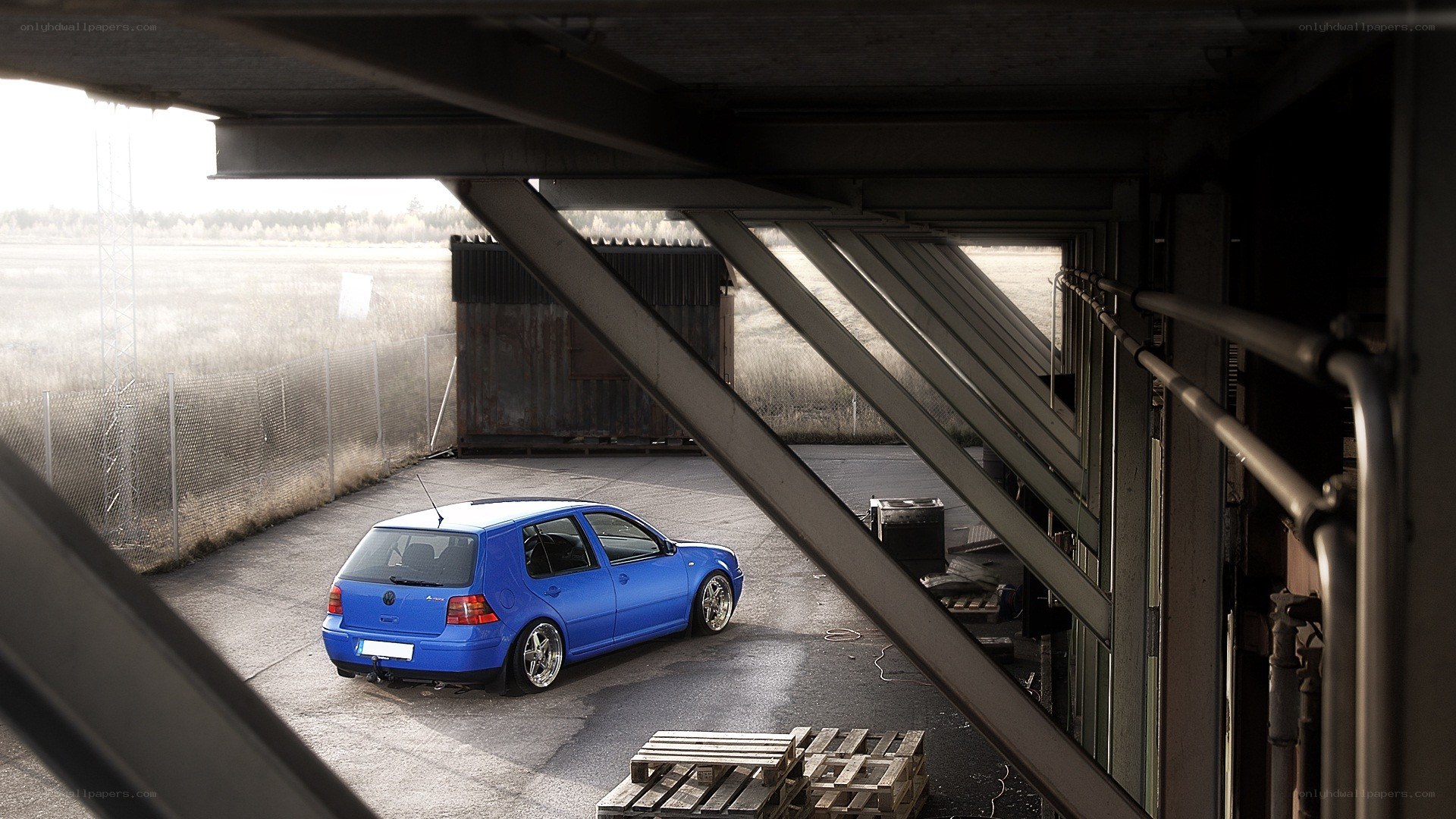 Blue car under industrial structure