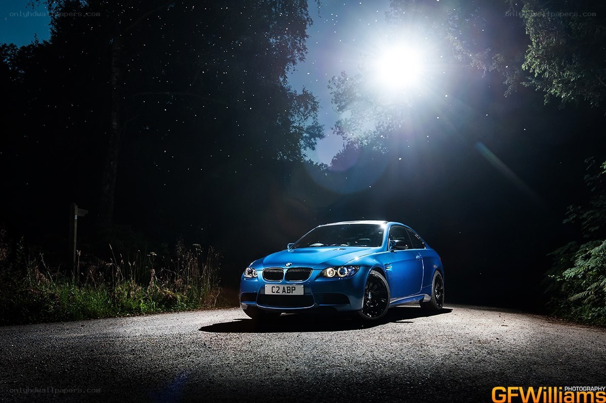 Blue car under night spotlight