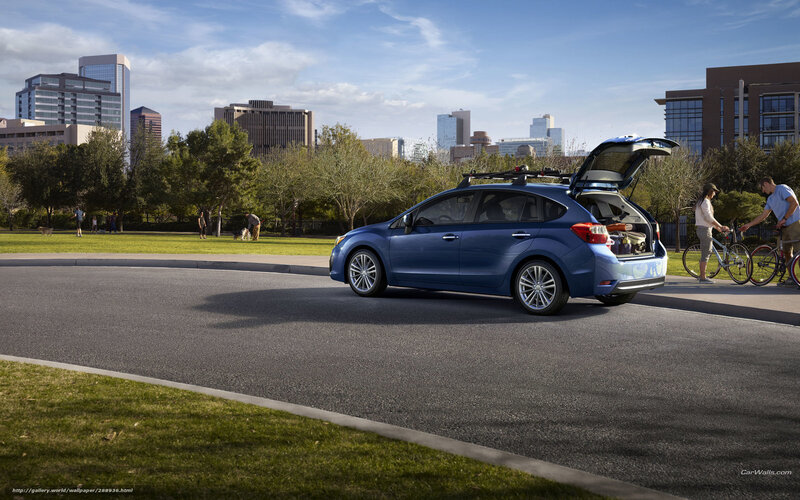 Blue car with open trunk in city park
