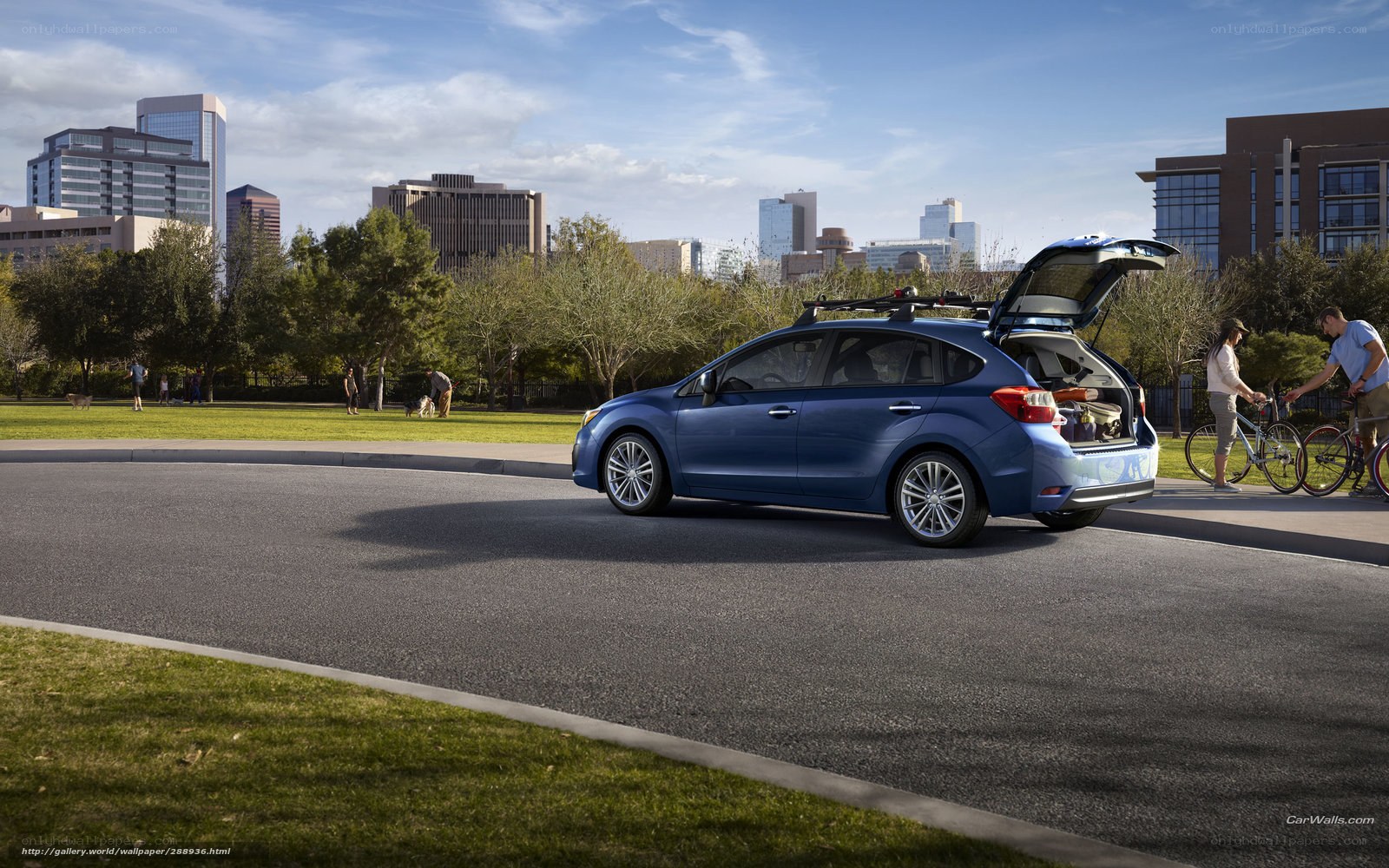 Blue car with open trunk in city park