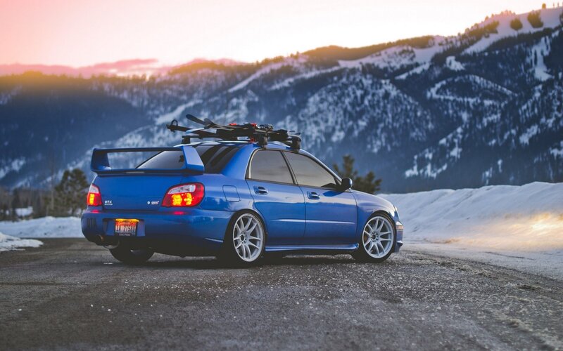 blue car with skis in mountains
