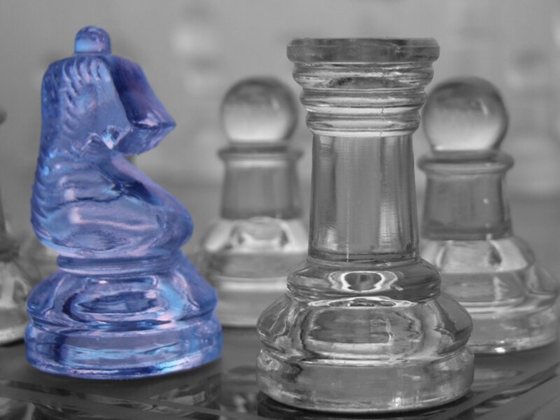 Blue chess piece on glass board
