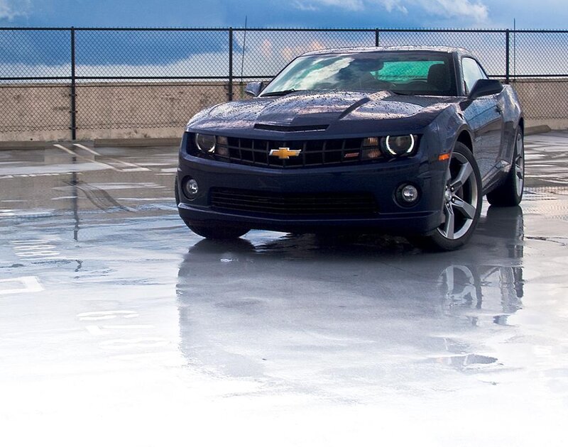Blue Chevrolet Camaro on wet pavement