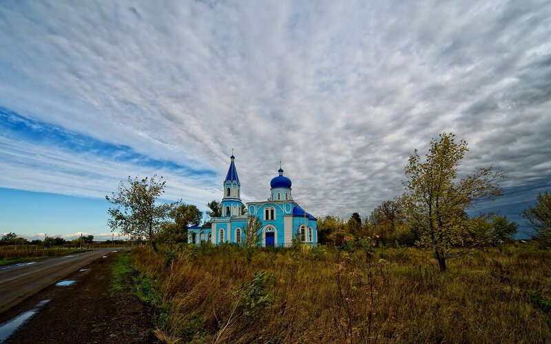 Blue church in rural landscape