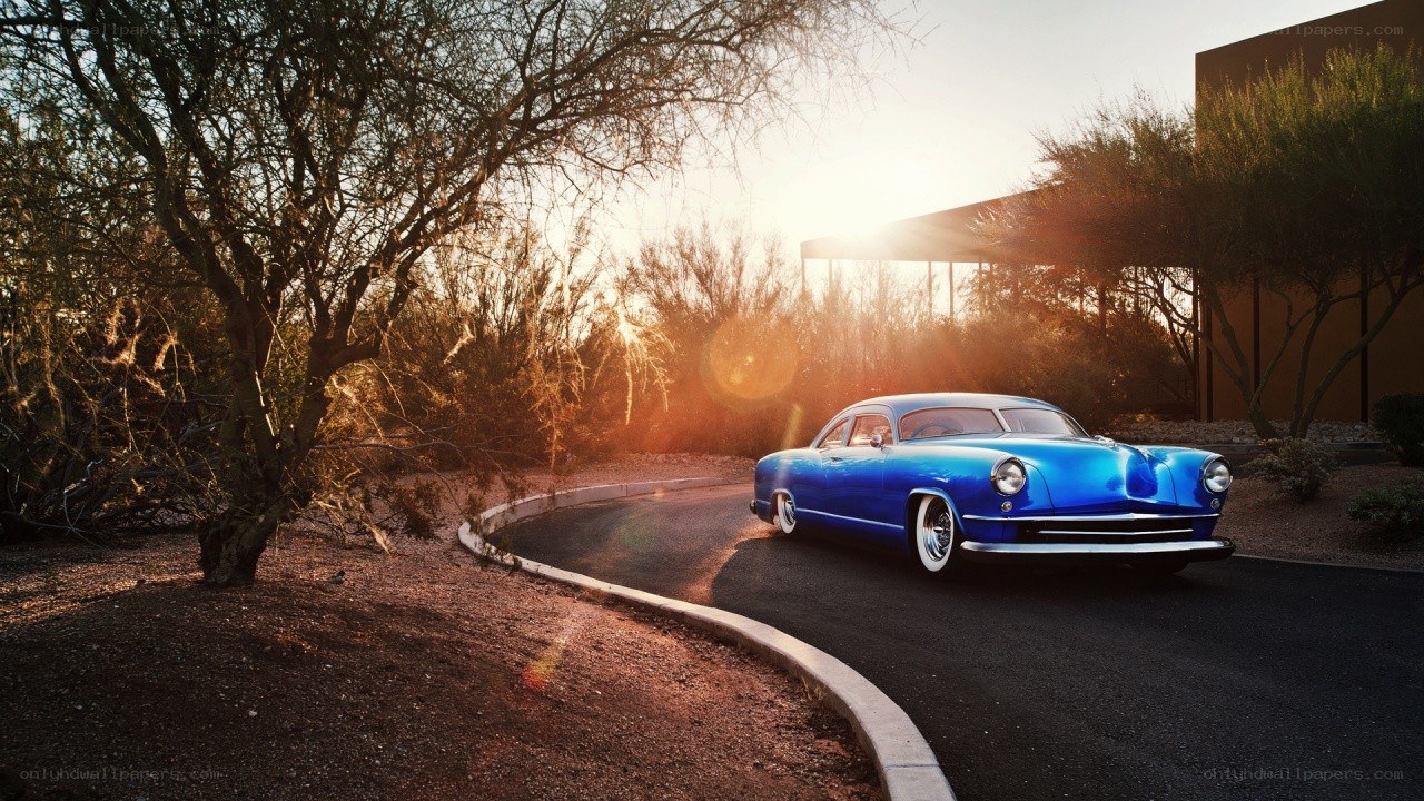 Blue classic car at sunset