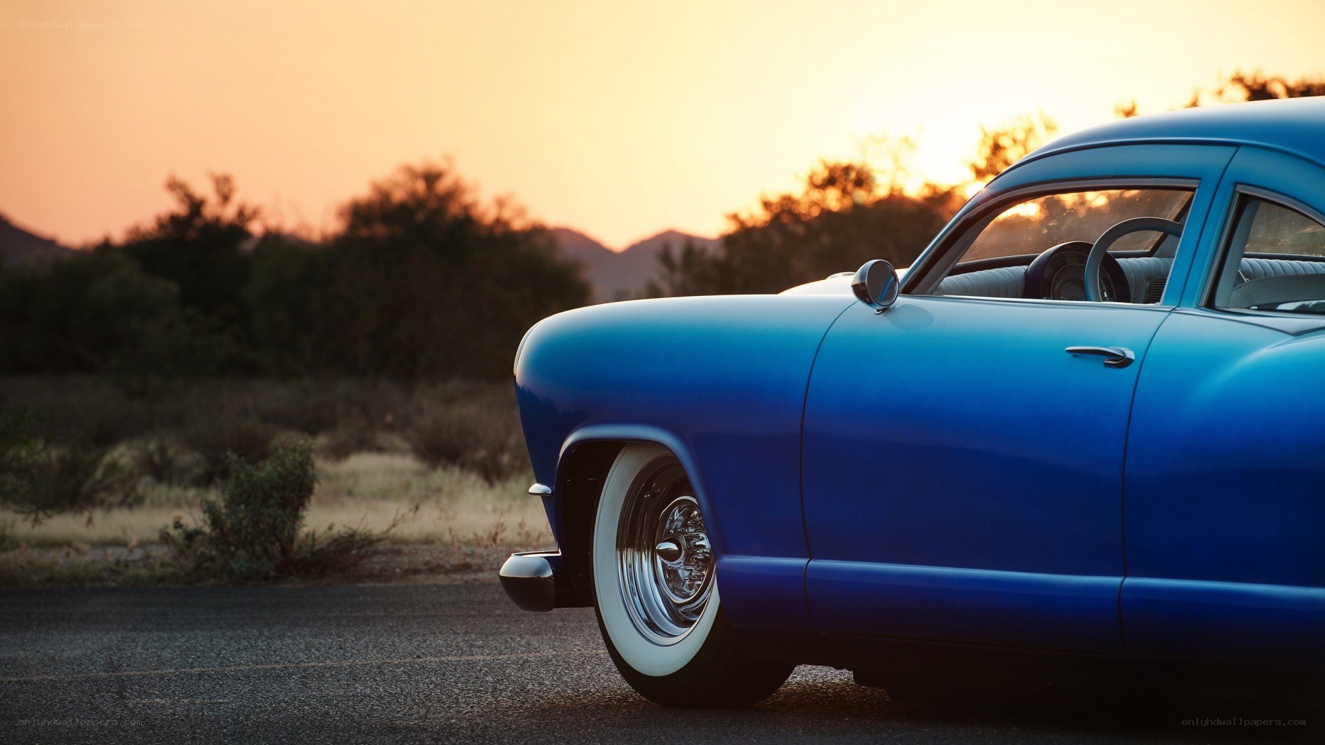 Blue classic car at sunset