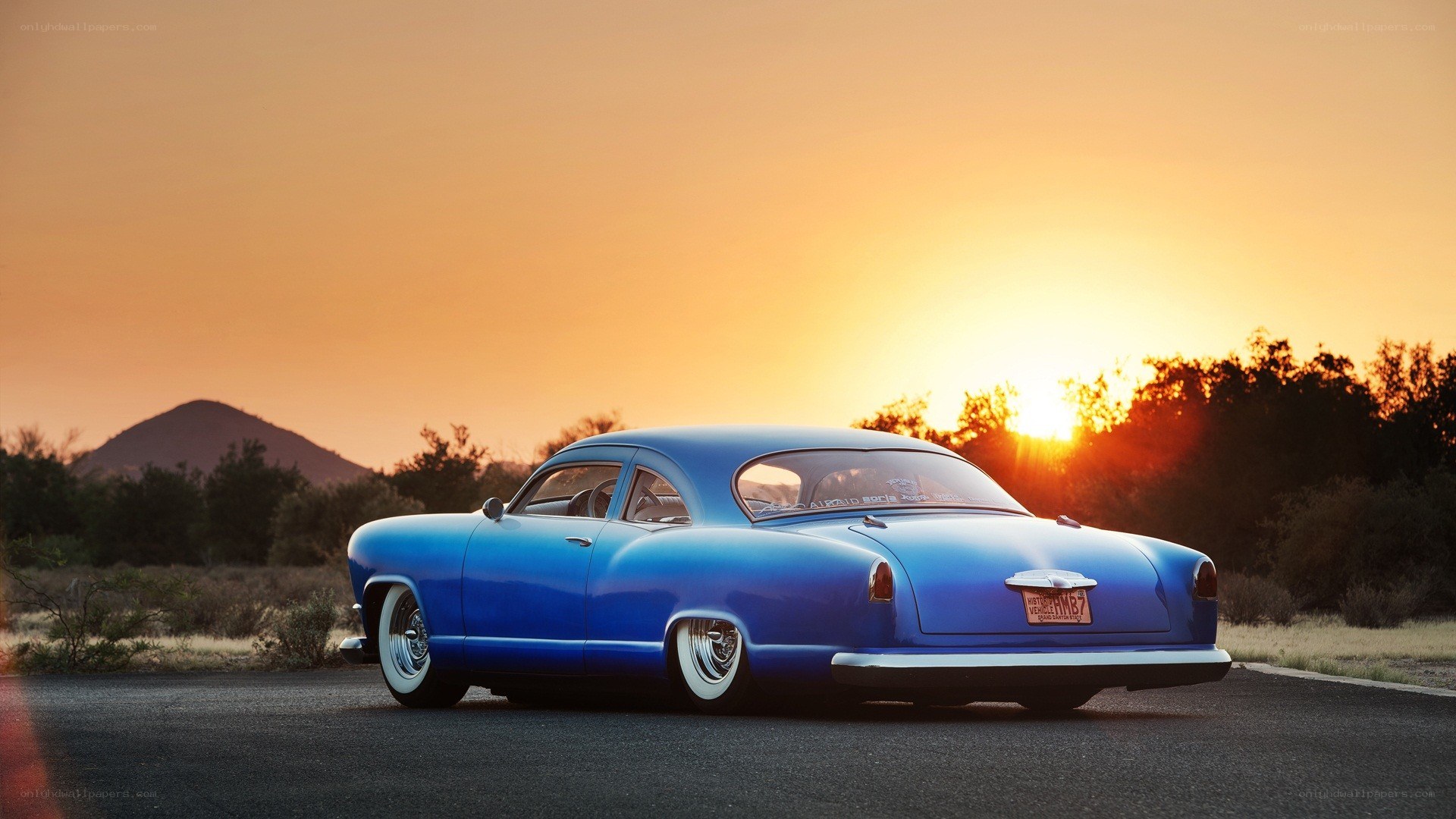 Blue classic car at sunset