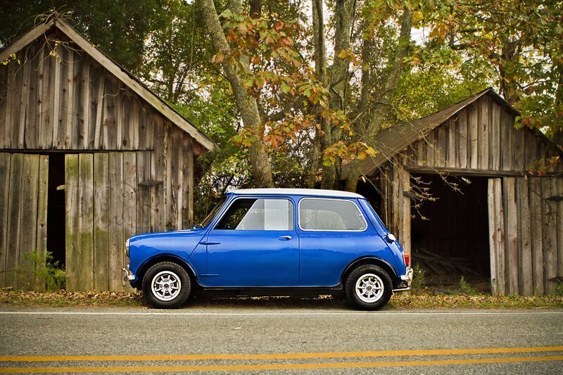 Blue classic car by wooden sheds