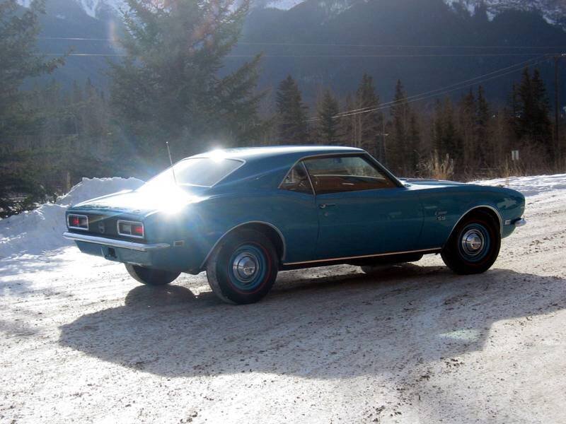 Blue classic car in snowy landscape