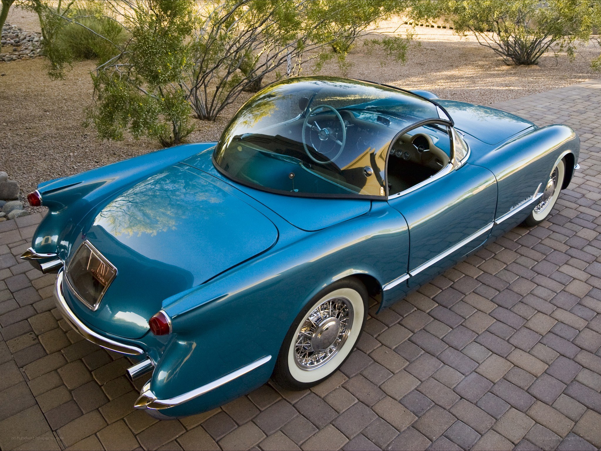 Blue classic car on brick driveway
