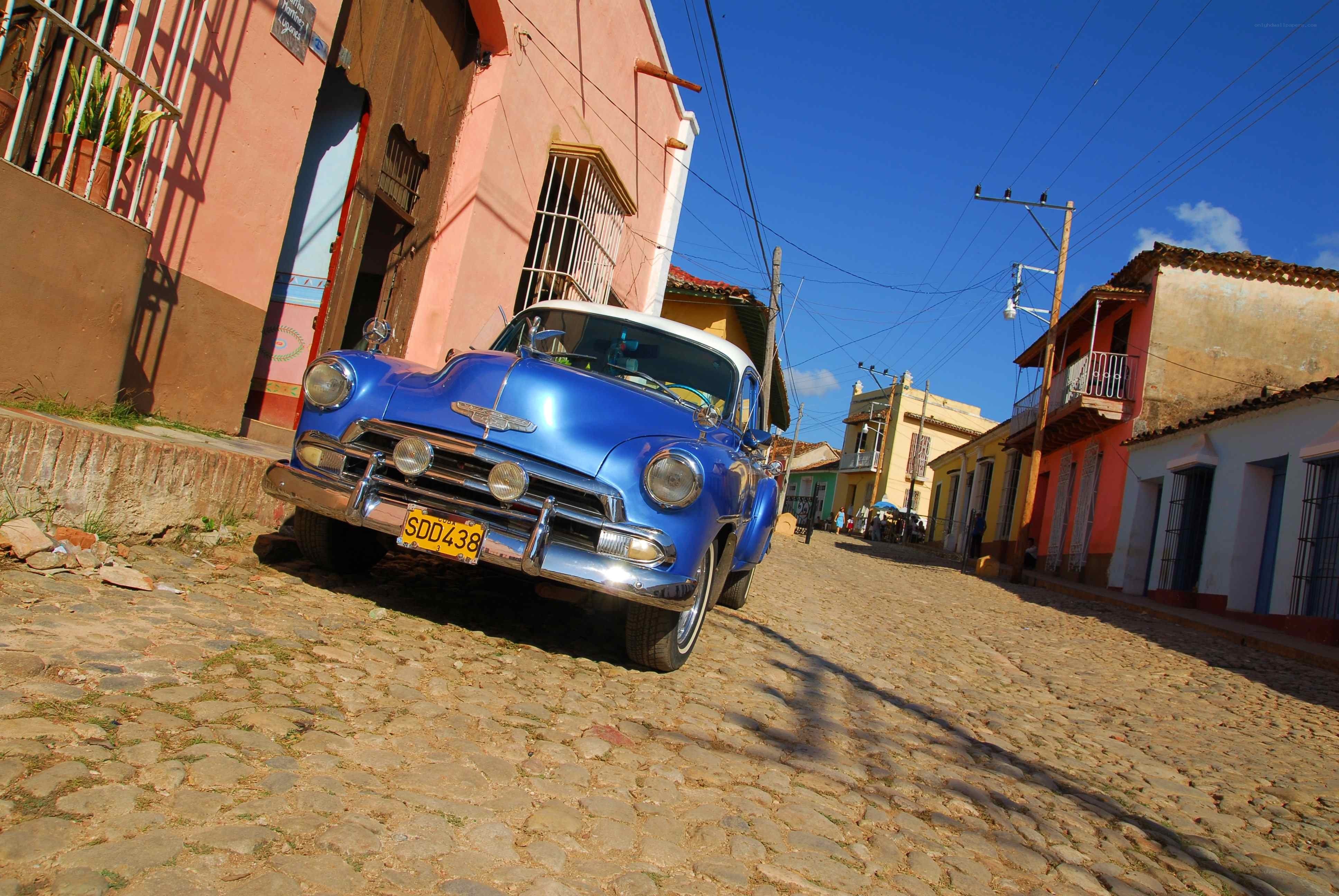 Blue classic car on cobblestone street