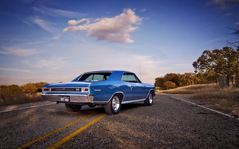 Blue classic car on country road