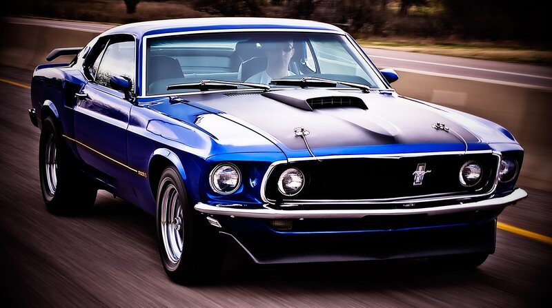 blue classic muscle car in motion