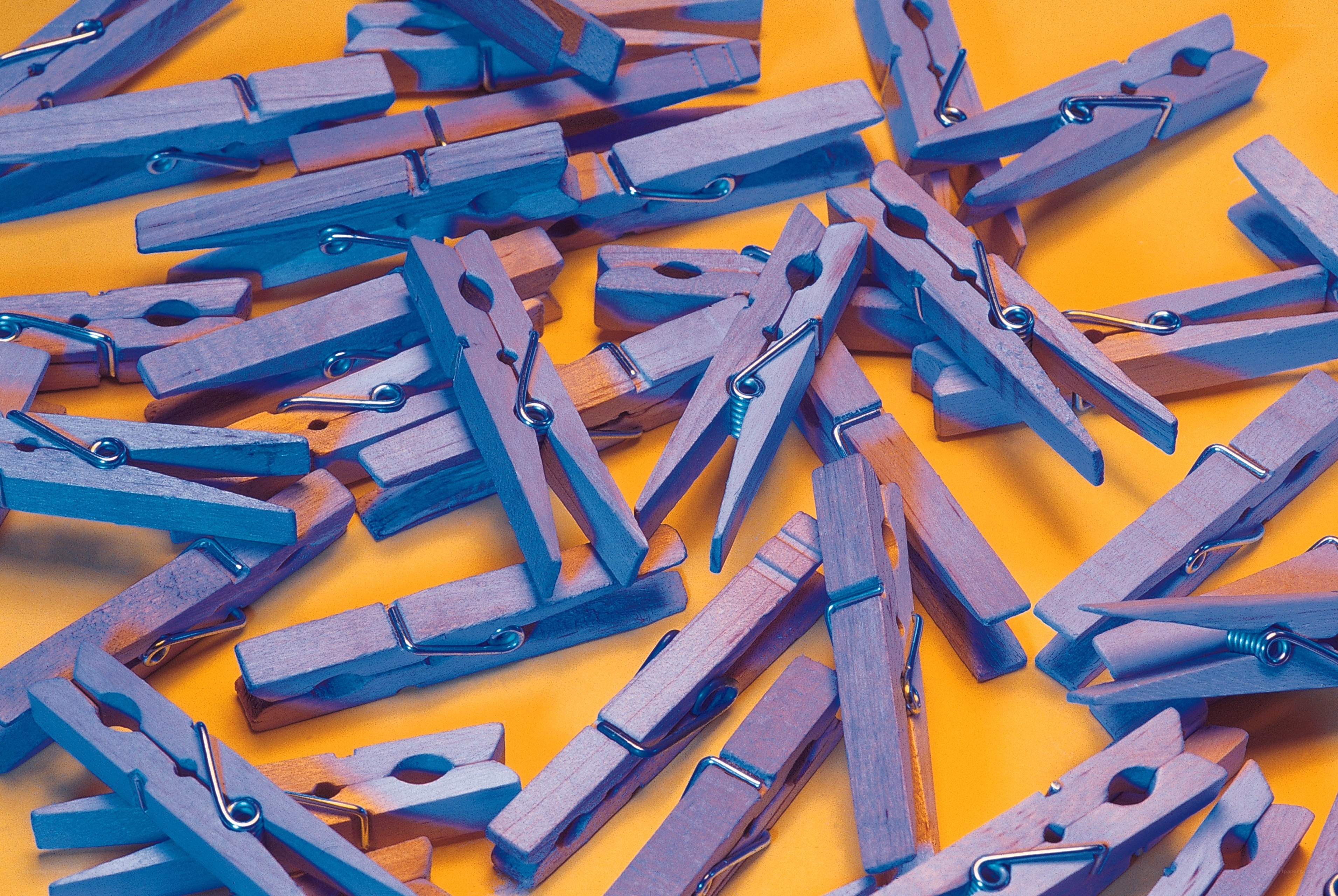 Blue clothespins on orange surface