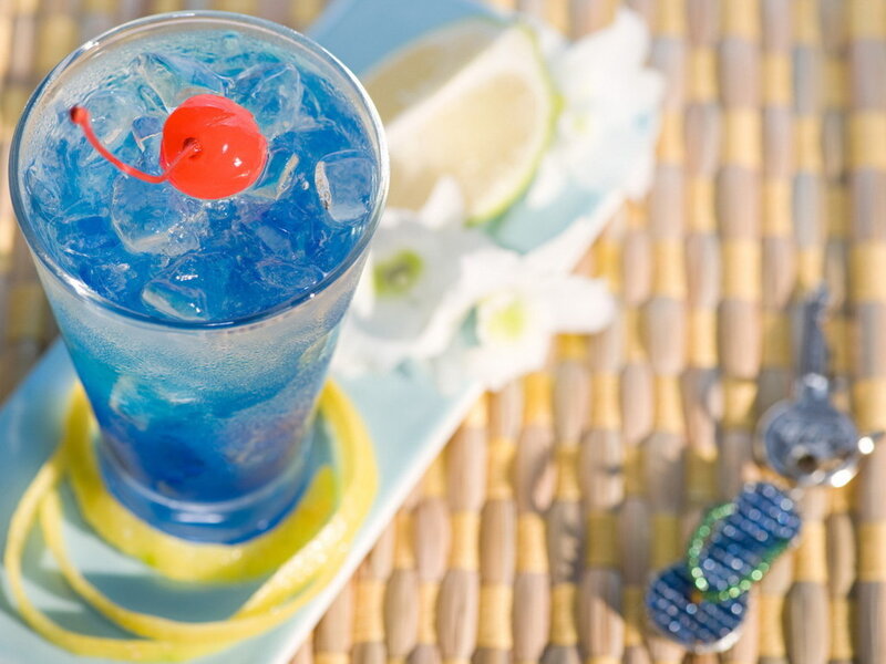 Blue cocktail with cherry garnish