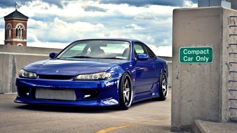Blue compact car on a bridge