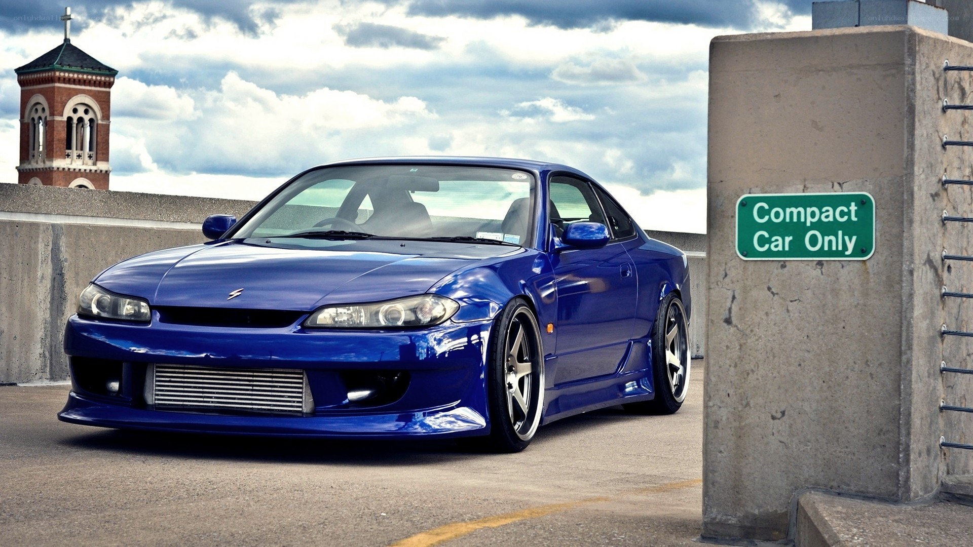 Blue compact car on a bridge