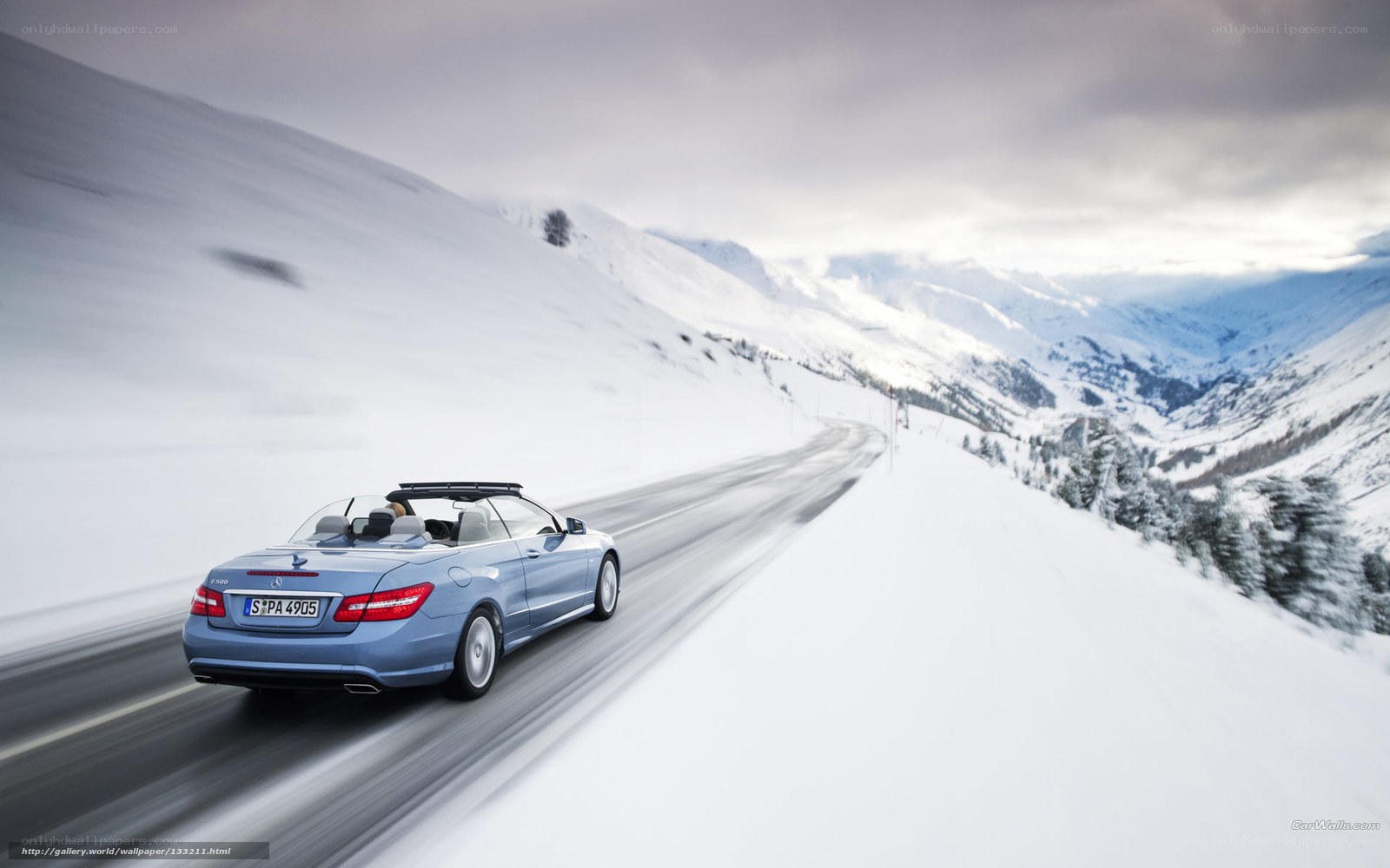 Blue convertible on snowy mountain road