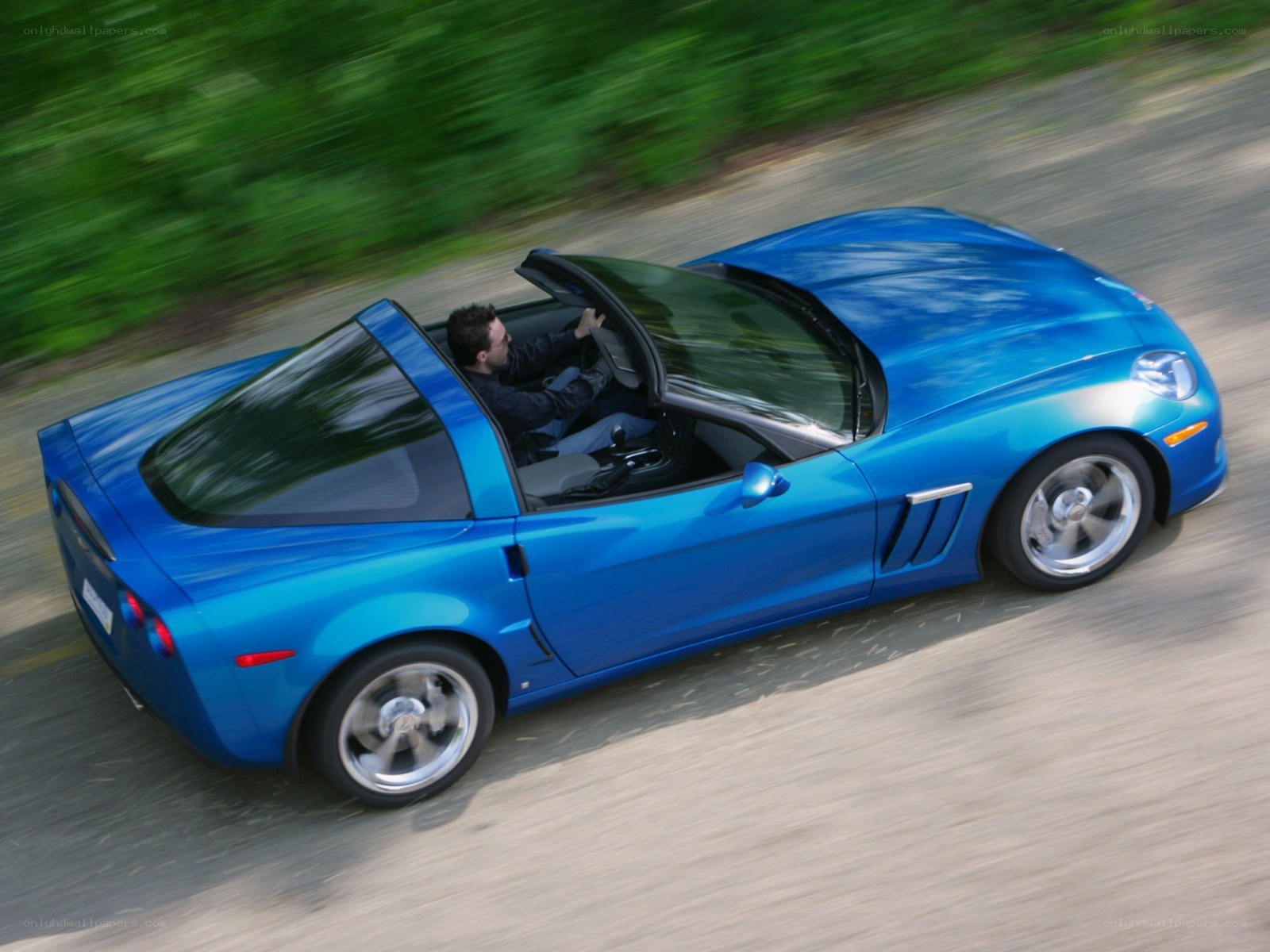 Blue Corvette driving on road