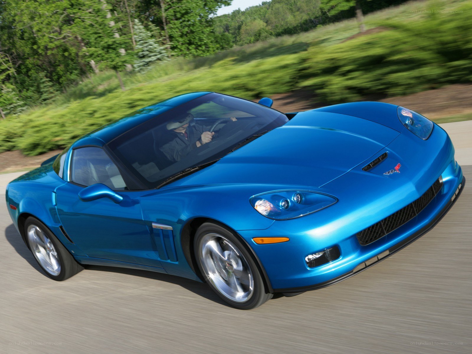 blue corvette driving on road