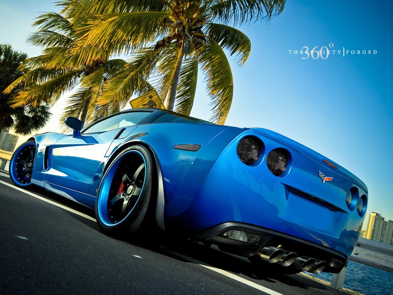 Blue Corvette on a tropical road
